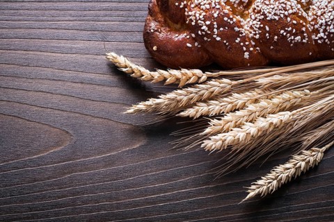 Sweet roll wheat rye ears on wooden background food and drink concept