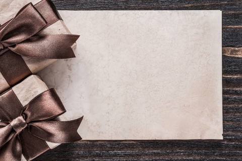 Wrapped boxed gifts paper on vintage wooden board holiday concept