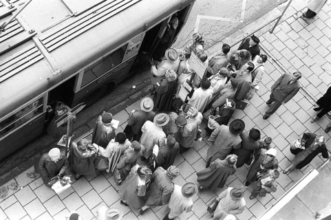 Bus stop in Stockholm in 1953. People are waiting for the bus at the bus stop. Bus 32 travelling on