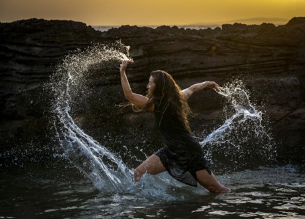 Middle-aged woman dancing and throwing water in the air, Maioris beach, llucmajor, Majorca,