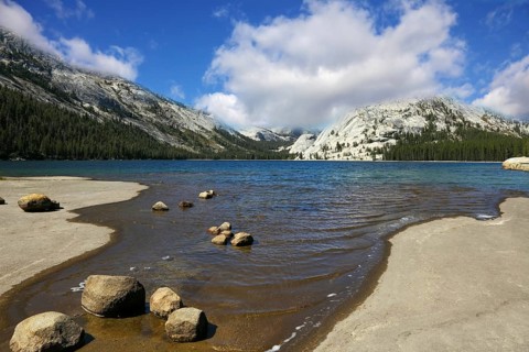Flat coast of shallow lake in mountains of national park Yosemite