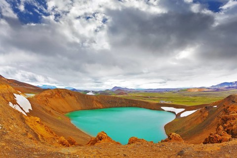 Summer in Iceland. Picturesque lake in the crater of an extinct volcano. Lake water bright green