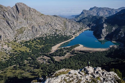 Hiker watching Gorg Blau reservoir, Escorca, Mallorca, Balearic Islands, Spain
