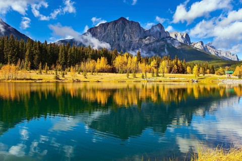 The Canadian Rockies. The city of Canmore in Banff Park. Bright autumn forest is reflected in the