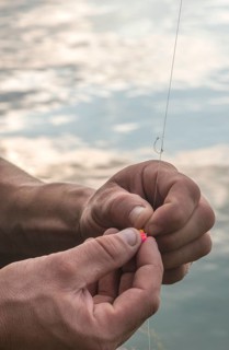 Man prepare rod for fishing. Mountain lake