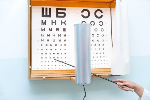 A Russian eye chart at an oculist and a hand with a pointer