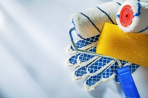 Safety gloves paint rollers on white surface