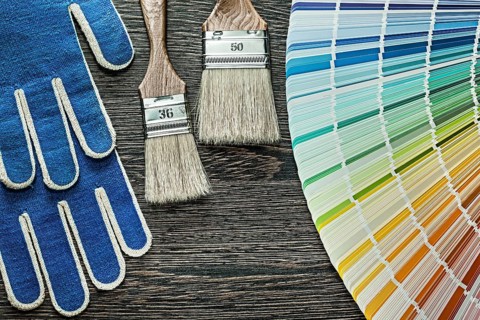 Safety gloves paint brushes pantone fan on wooden board