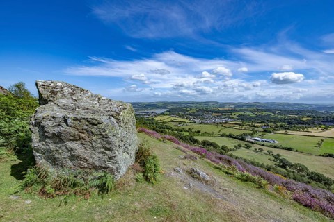 View from the mountains to Conwy Castle, medieval castle ruins surrounded by green fields and blue