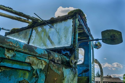 Old car rolled for scrapping in a meadow. Alsace, France