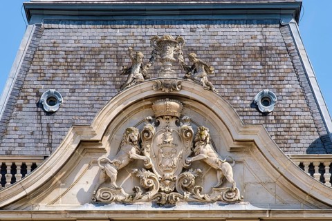 Rampant lions hold up the coat of arms of Festetics family on the tower of Festetics Palace,