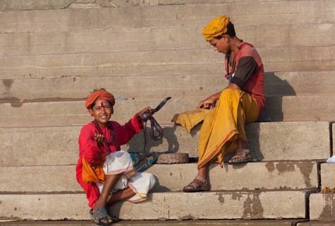 Children with cobra at ghat steps on river Ganges, Varanasi, Uttar Pradesh, India