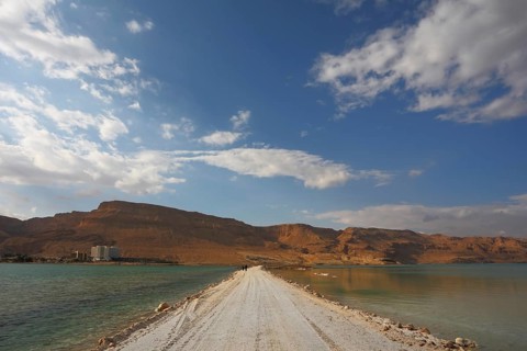 Sunset. Incredible lighting effects in a thunderstorm at the Dead Sea. The road in the middle of
