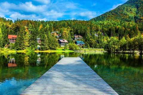 Travel to fabulous Slovenia. Lake Jasna in the Eastern Julian Alps. Wooden pier. The mountains are