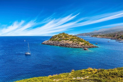 Holiday in Greece, island of Zakynthos. Bright blue sea water reflects coastal cliffs. Snow-white