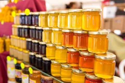 Different small jars of honey - herbal honey, lavender honey, linden honey and mixed honey