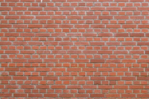 Bricks in an orange-red color in chain linked regulation to an old building in the Netherlands