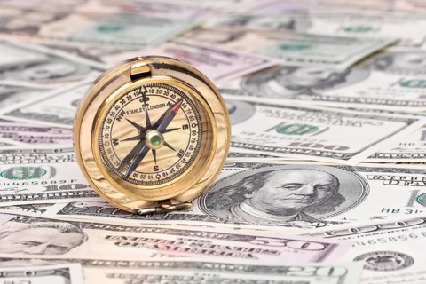 Many dollar banknotes and compass. Symbolic photo for economic crisis Austria