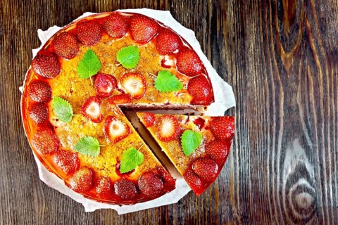 Pie with strawberry, kissel, jelly and mint on a parchment background on wooden board on top