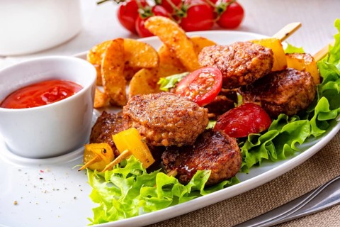 Meatballs skewers of tomato, paprika and baked potato quarters