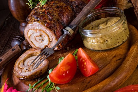 Rolling roasts fullly with dried fruit and bacon