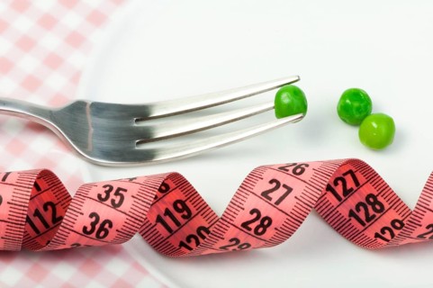 Plate with peas and centimeter measure close up