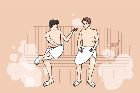 Happy male friends in towels relax in sauna on weekend together. Smiling men enjoy bathhouse
