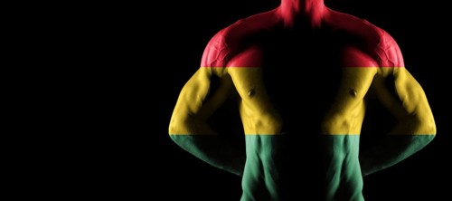 Ghana flag on muscled male torso with abs, black background