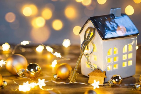 Key to the house with a keychain on a lamp with a Christmas decor. A gift for New Year, Christmas.