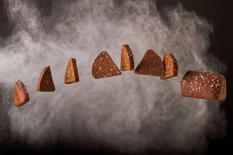 Hanging bread slices with sunglower seeds on smoke background. Bakery food concept