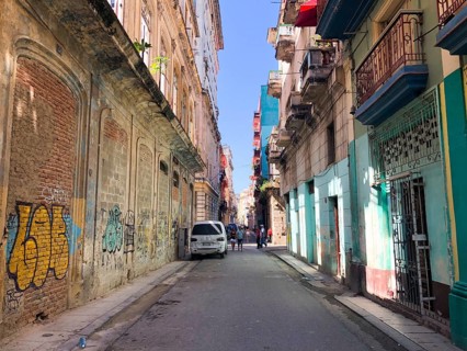 Street scene with colorful and old building on Havana. Urban scene with people and aged buildings
