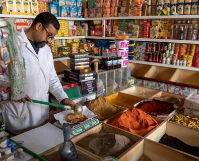 Er-Rich, Morocco, 7 March, 2024: Moroccan shopkeeper mixing spices in his shop in the market of