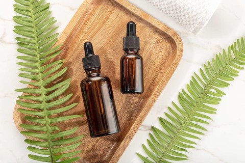 Essential oil bottle on wooden tray. Beauty, skin care, wellness. Yop view