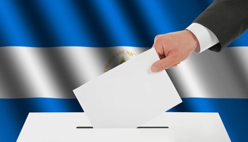 The Nicaragua flag and the hand with the bulletin about the ballot box