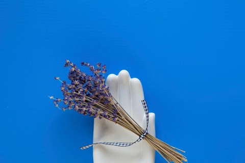 Detail of ceramic hand and bouquet lavender flower on the blue wooden table - Flat Lay Photography