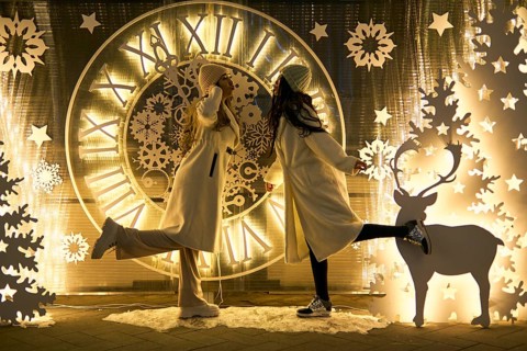 Two girlfriends asian girls in white coats are having fun hugging, new year, light bulbs