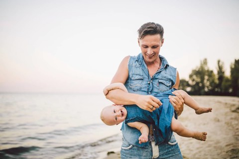 Theme Fatherhood and rest with a child at sea. Young handsome Caucasian father plays plays enjoys