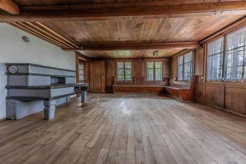 The living room with tiled stove and wooden corner bench in a house built around 1750 that has
