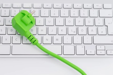 Green power plugon a keyboard isolated on white background