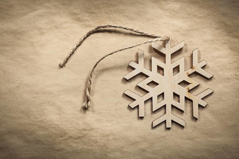 Vintage wooden snowflake string on paper background holidays concept