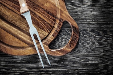 Meat fork cutting board on wood background