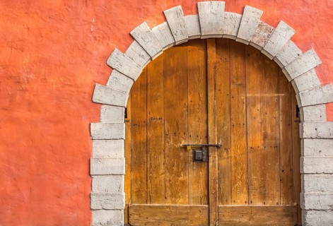 Medieval building entrance with an arched double door, made from hard wood