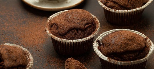 Chocolate and cocoa browny muffins with coffee cappuccino in cup angle view on brown rustic stone