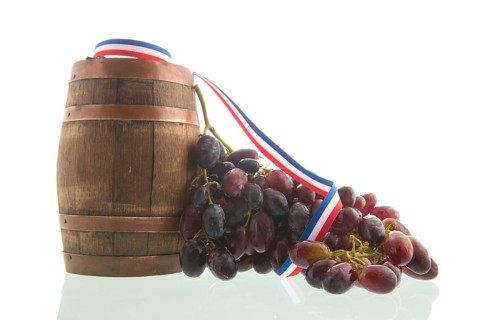 Old wooden wine barrel and buch of red grapes isolated over white background
