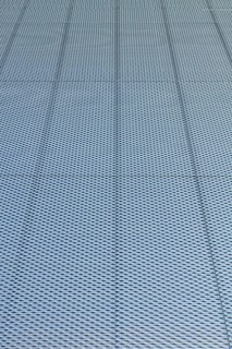 Closeup of metal mesh on concrete wall background texture