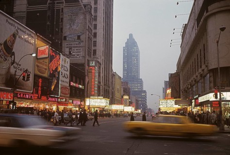 USA New York 1967. Broadway in the evening with cars and people visible and signs on all the