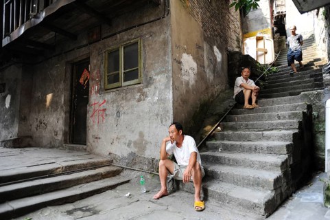 04.08.2012, Chongqing, China, Asia, Men sit on the steps in front of a house in the old town of