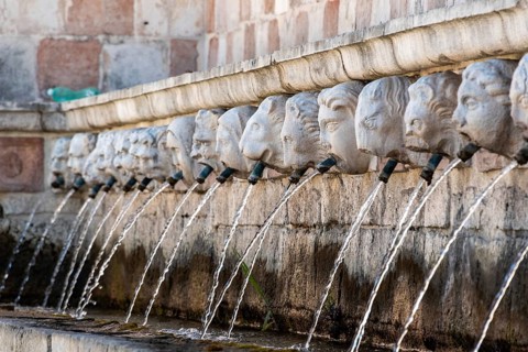 Famous mediaeval Fountain of 99 Spouts in ithe old town of L'Aquila, Abruzzi in Italy