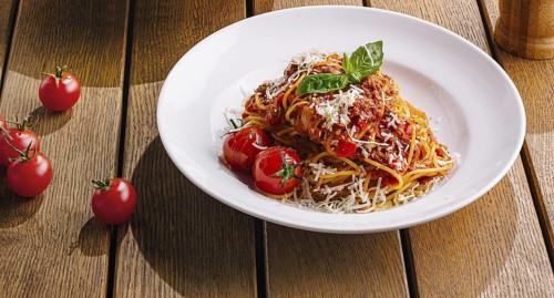 Food, Pasta dish beautifully presented on a warm, wood table setting, evoking a cozy italian dining