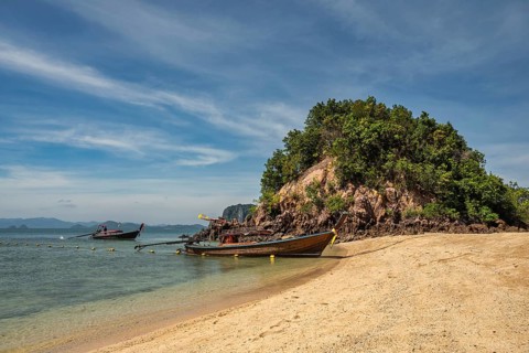 Tropical islands view with long tail boat ocean blue sea water and white sand beach at Koh Phak
